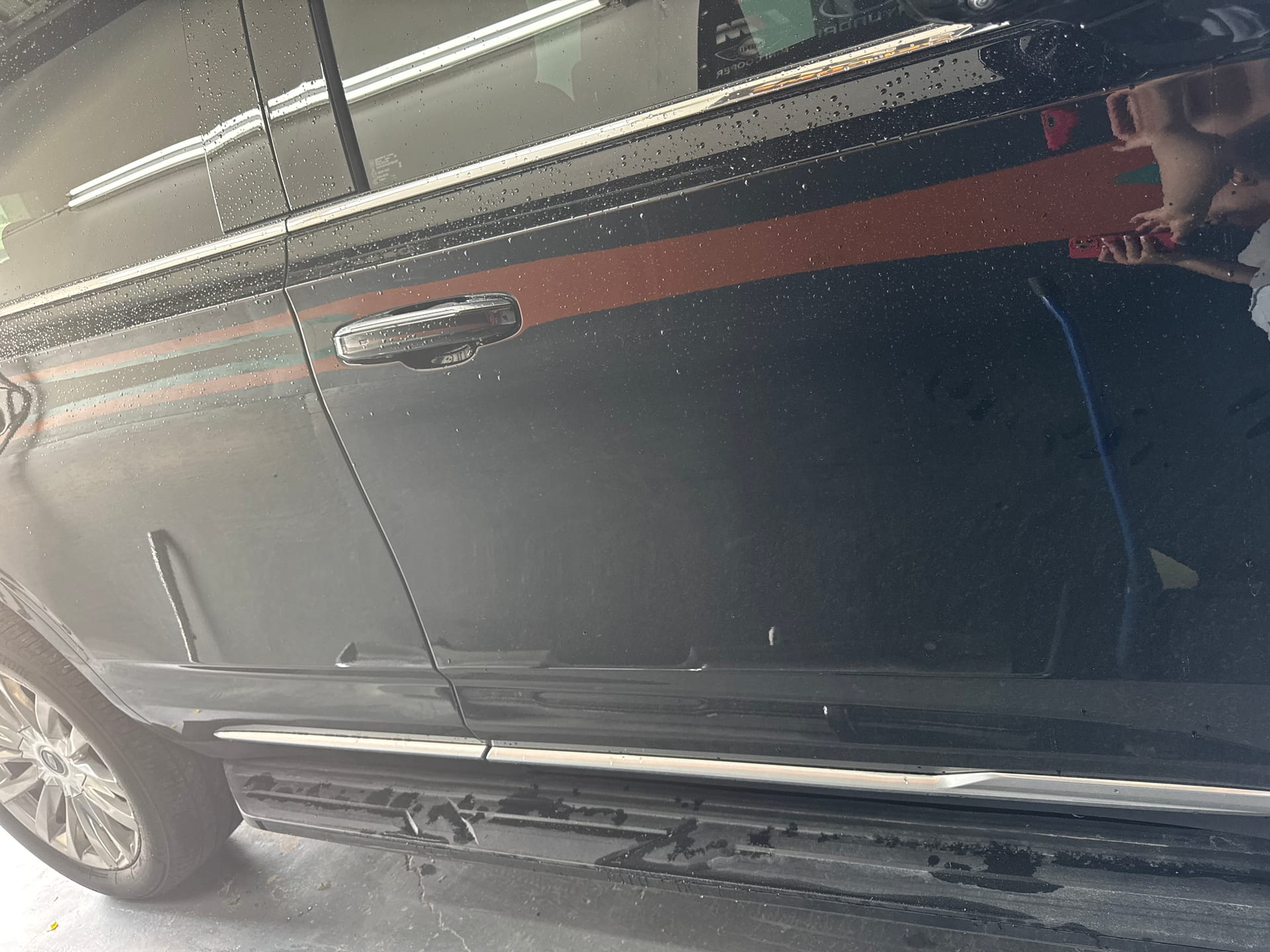 Black SUV with refinished side panels, still wet after a wash at KAG Auto Collision Center