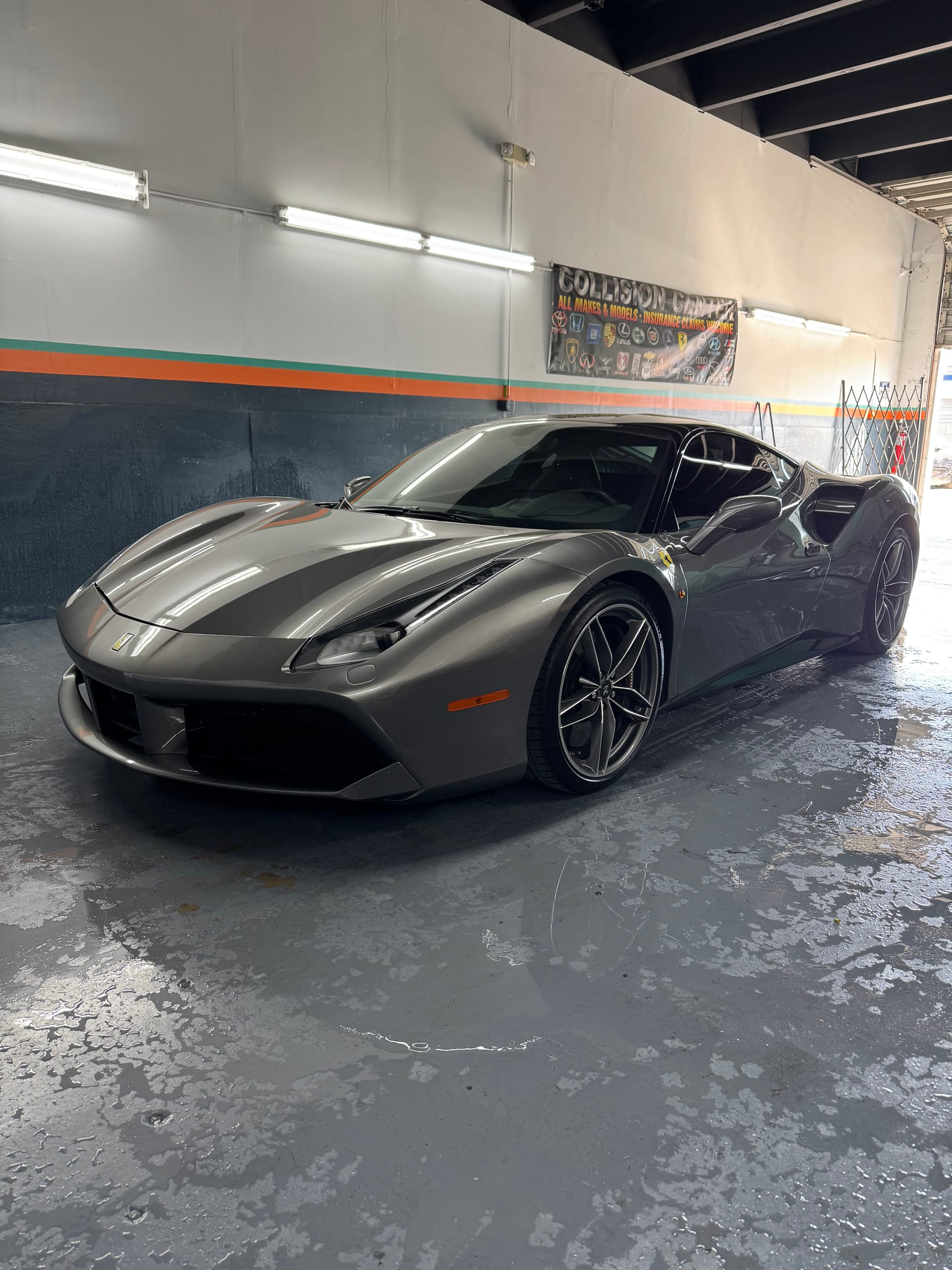 Ferrari 488 GTB in gloss grey inside the KAG Auto Collision Center shop