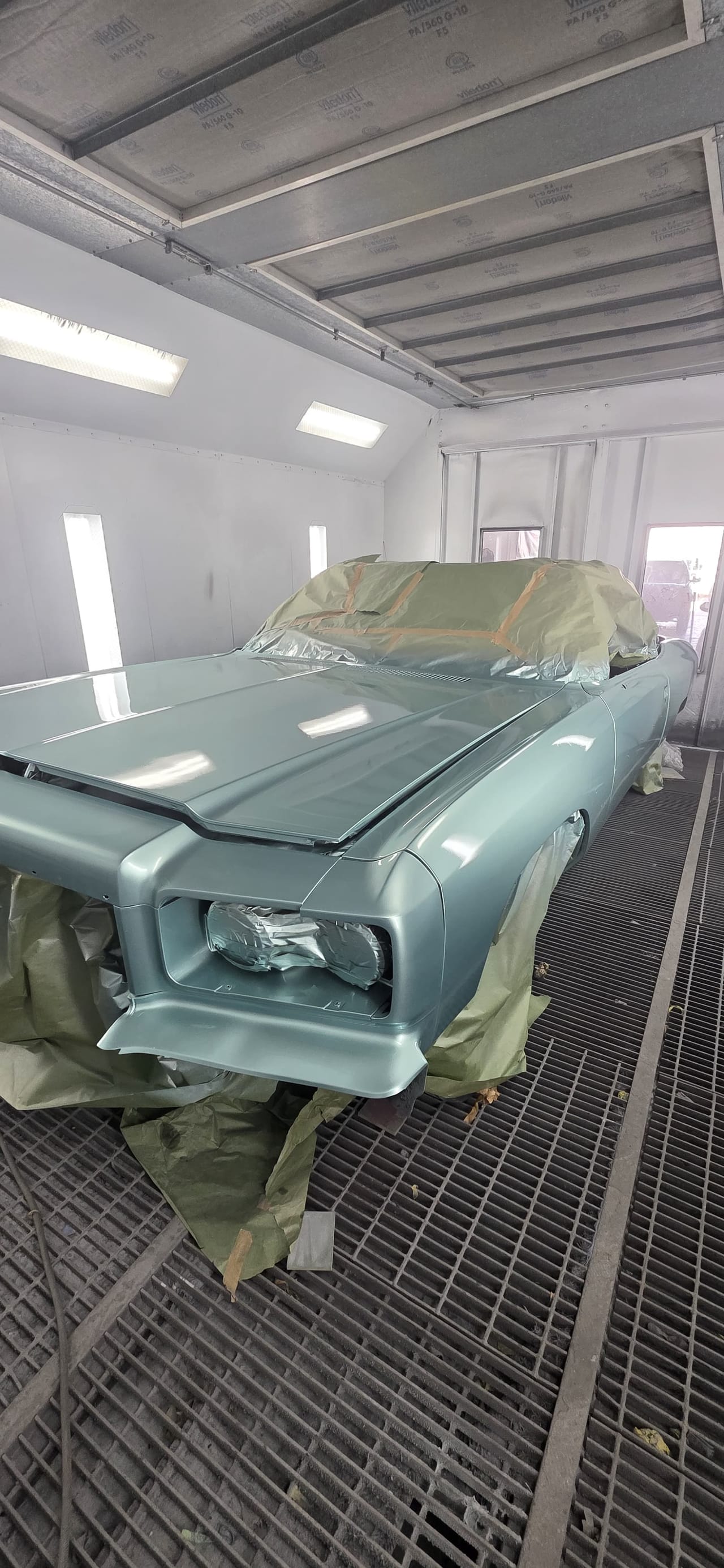 Fresh light blue base coat going on the same Malibu inside the booth
