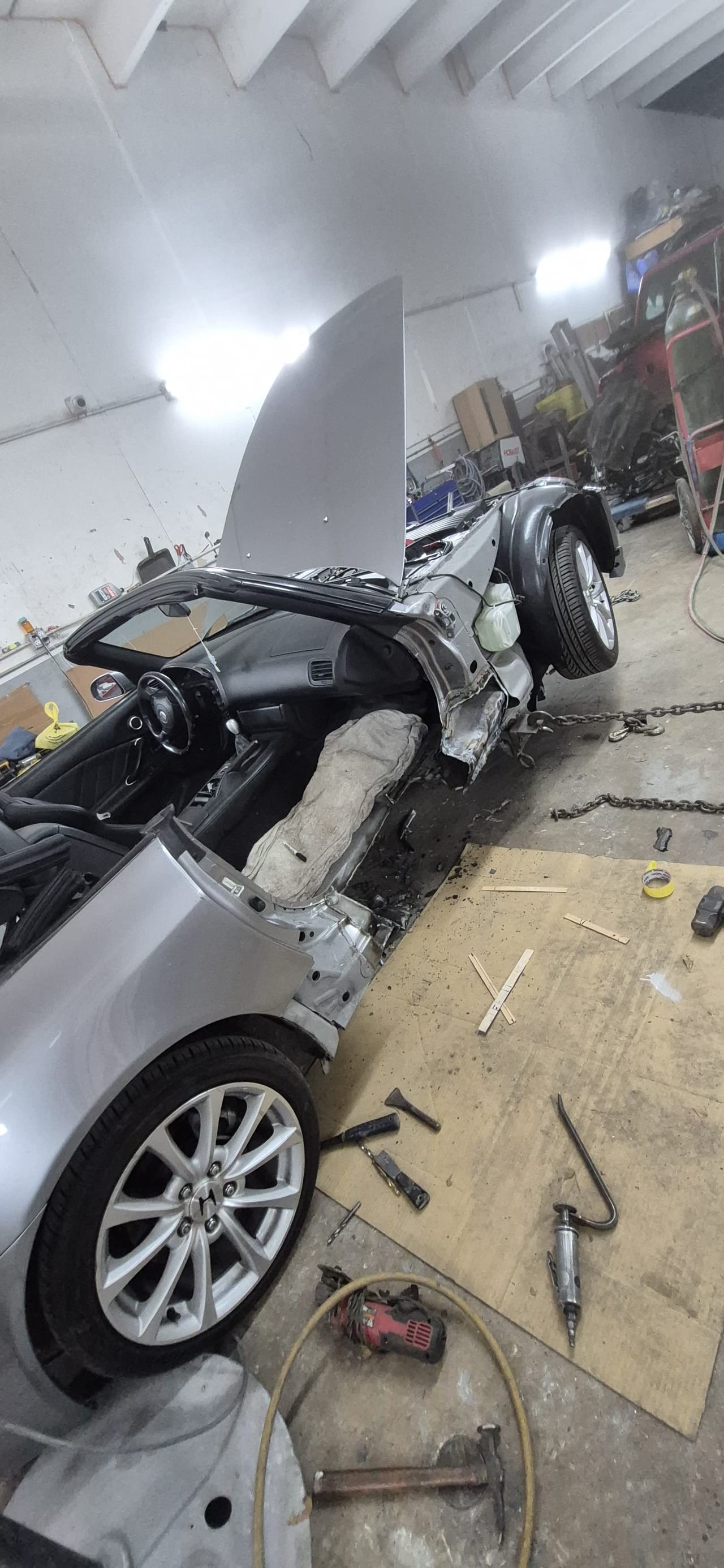 The roadster chained on the frame rack for structural straightening